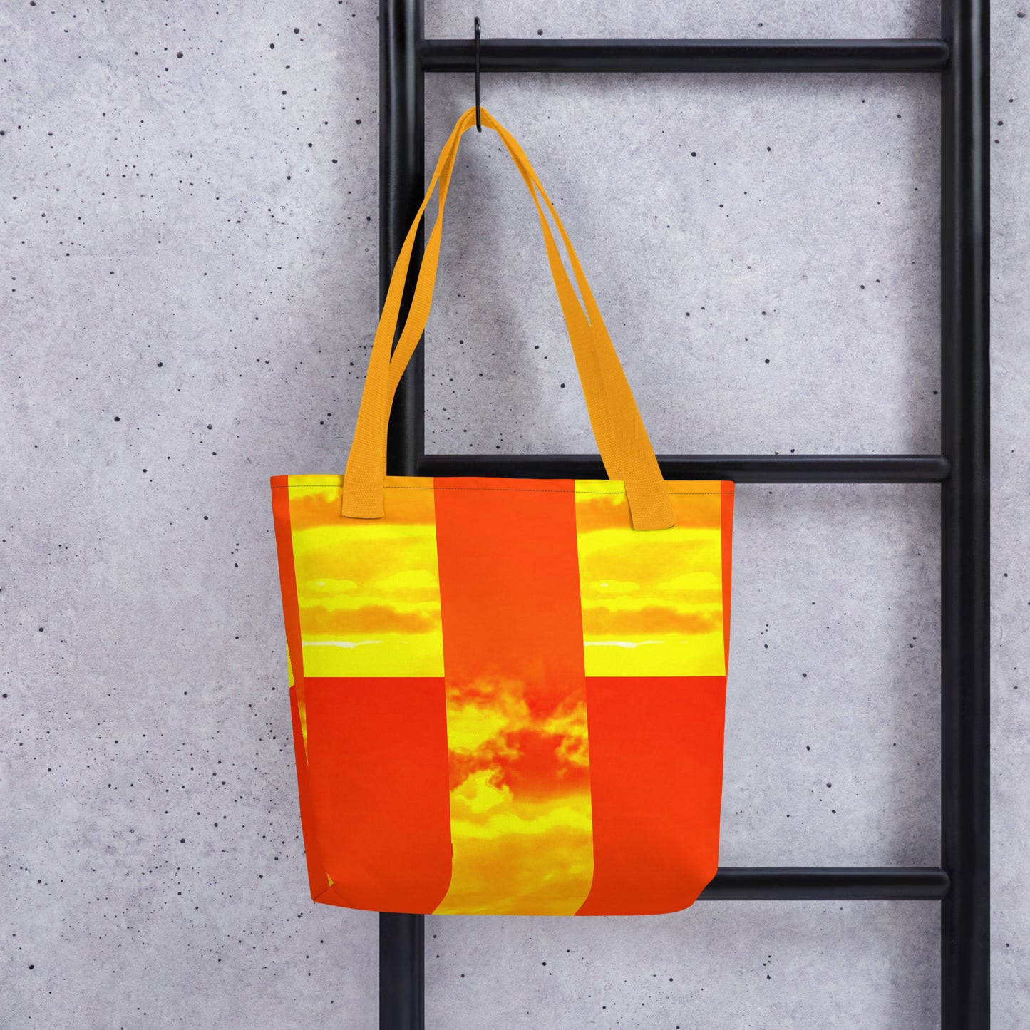 Summer beach tote bag THE PERFECT SUNSET PRINT with vibrant orange and yellow design hanging on black metal rack