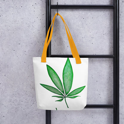 White canvas shopping tote with leaf design and yellow handles hanging on black ladder