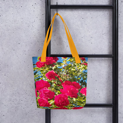 Eco-friendly summer beach bag ROSE PRINT with vibrant pink roses and yellow handles hanging on black ladder