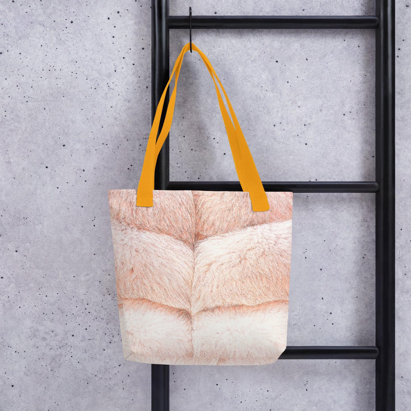 Faux fur print tote bag with beige fur design and yellow handles hanging on black ladder