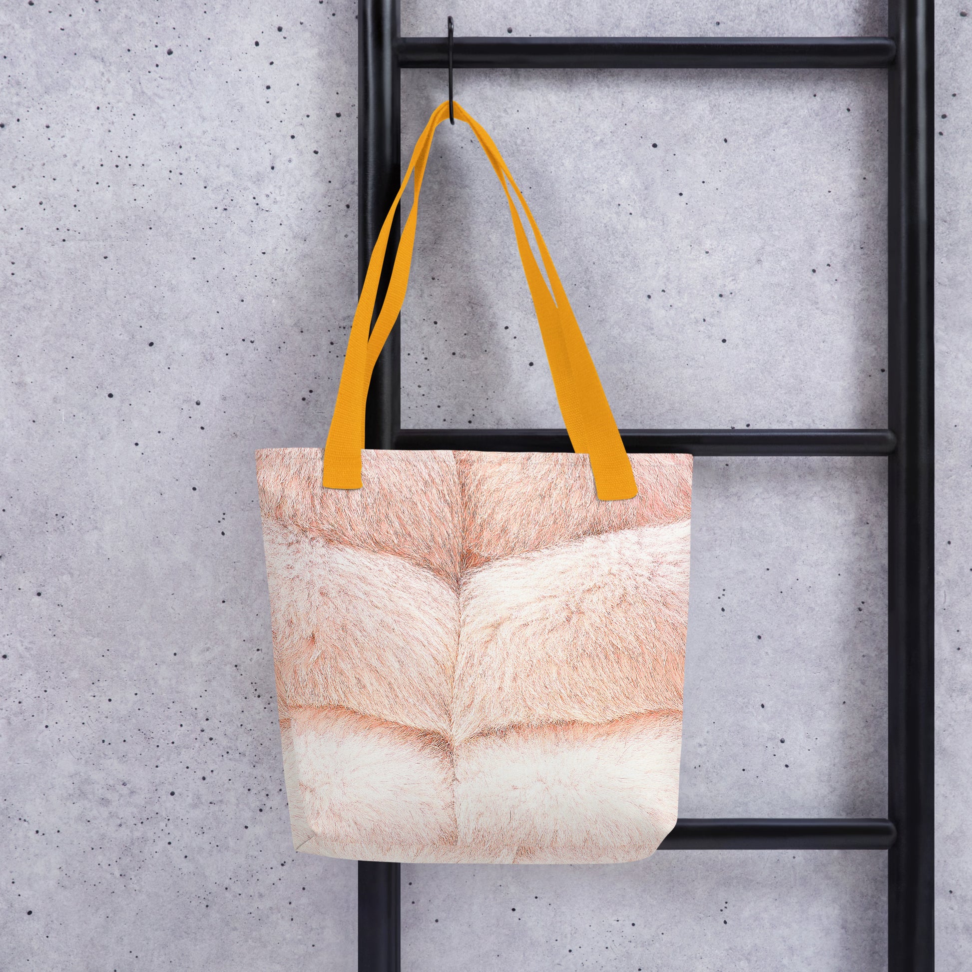 Faux fur print tote bag with beige fur design and yellow handles hanging on black ladder