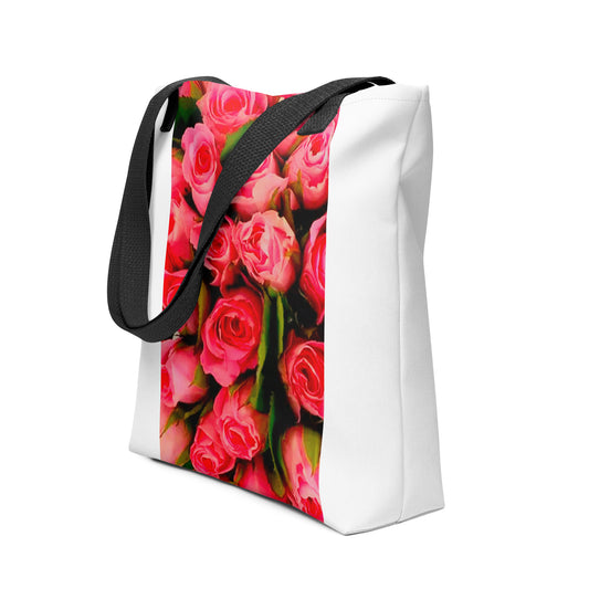 White tote bag with black straps featuring a vibrant pink rose print bag design