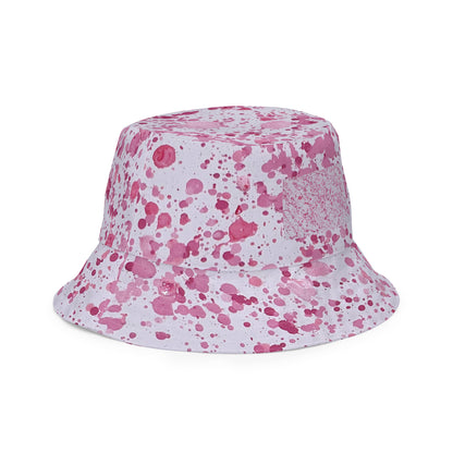 Pink splatter bucket hat from NUSH'S STORE with vibrant paint splatter design for festival wear