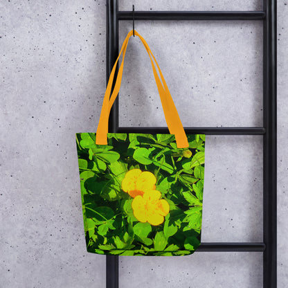 Summer beach tote bag BUTTERCUP PRINT with yellow flower design and bright yellow handles hanging on black ladder