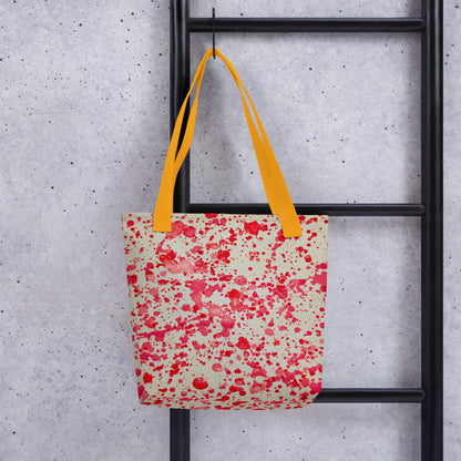 Unique designer tote bag women with red splatter pattern and bright yellow handles hanging on black ladder